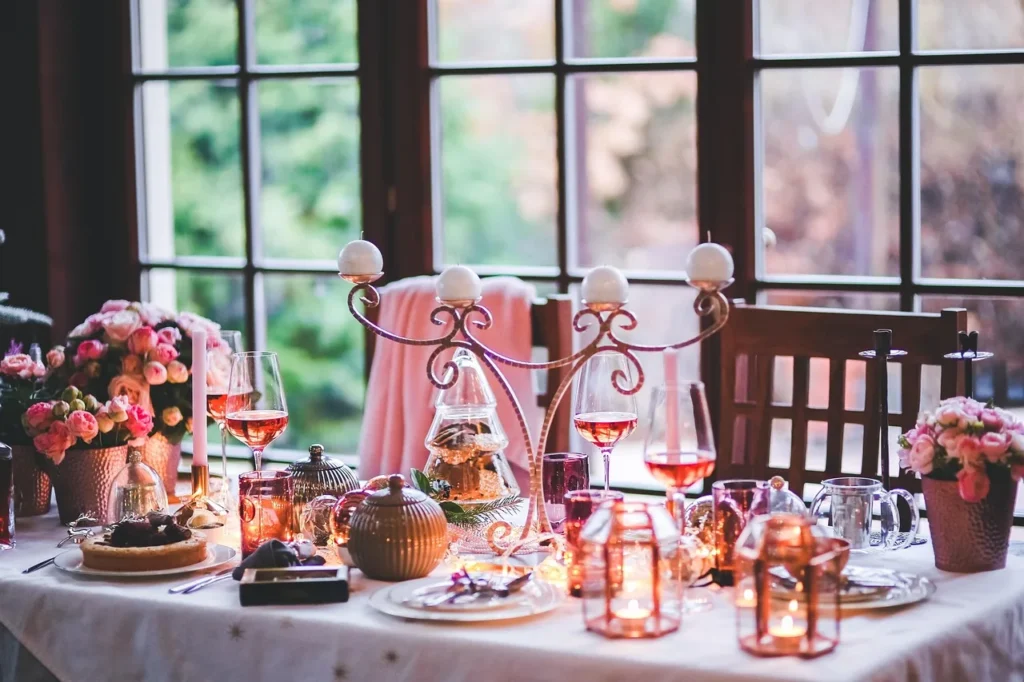 A beautifully arranged table setting featuring pink and white flowers alongside flickering candles.