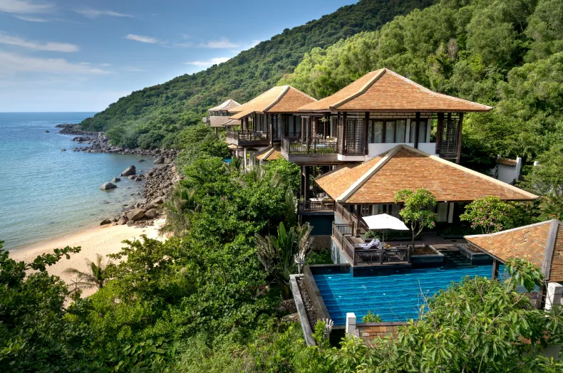 A beach resort featuring a pool with a stunning view of the ocean in the background.